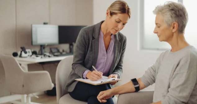 Comfort evaluation in medical device design showing researcher recording observations while assessing wearable device fit on a participant's wrist