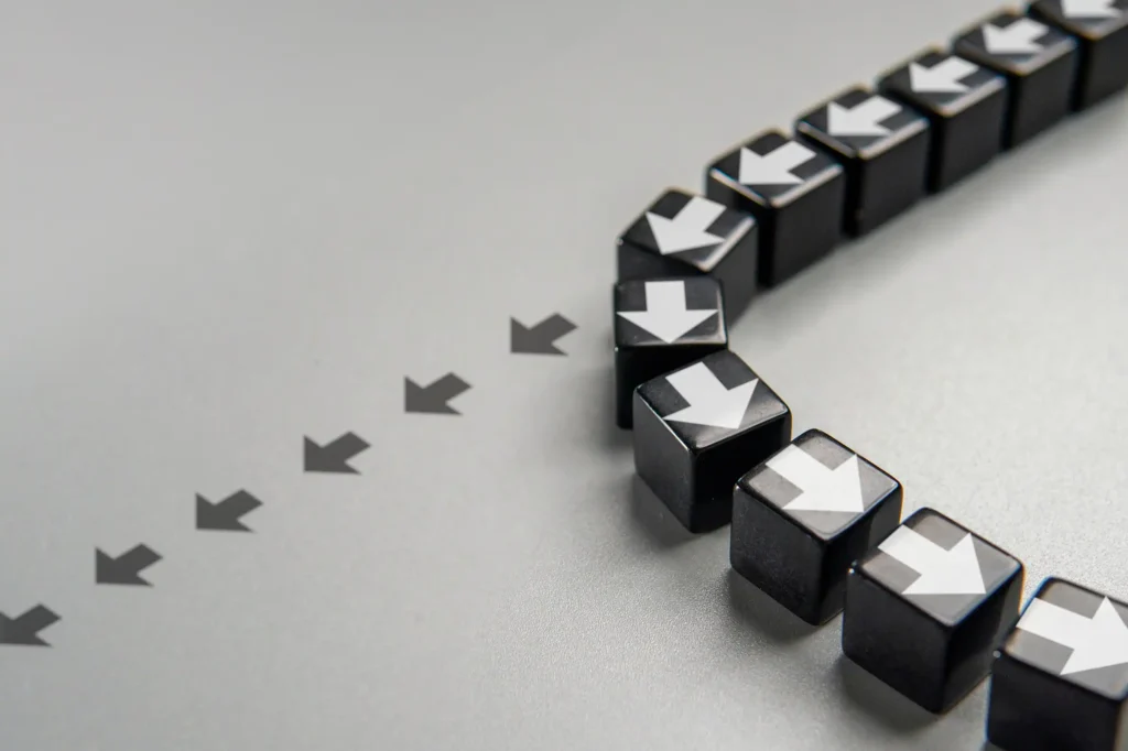 Black cubes with white arrows changing direction, symbolizing strategic pivots and disciplined commercialization in MedTech exit optimization.