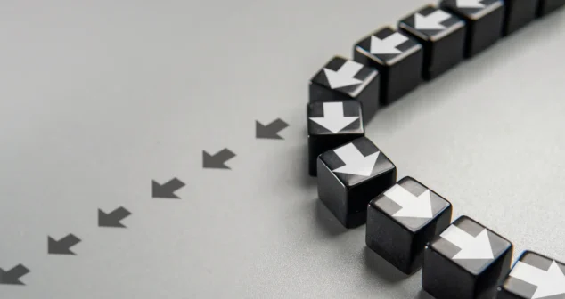 Black cubes with white arrows changing direction, symbolizing strategic pivots and disciplined commercialization in MedTech exit optimization.