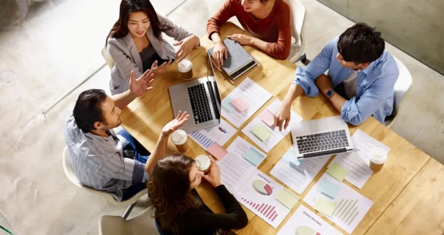 Team reviewing market data and planning a MedTech commercialization strategy around a table.