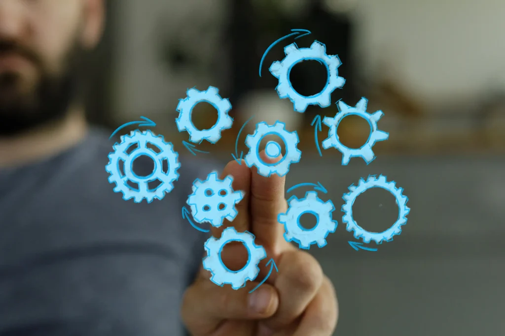 Engineer interacting with digital blue gears, symbolizing manufacturing readiness alignment and scalable MedTech commercialization.