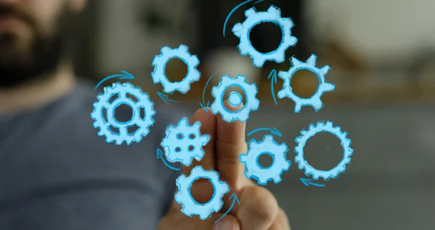 Engineer interacting with digital blue gears, symbolizing manufacturing readiness alignment and scalable MedTech commercialization.
