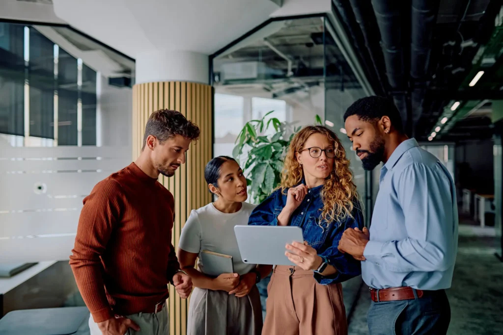 Cross-functional MedTech team discussing requirements on a tablet during a medical device development meeting.