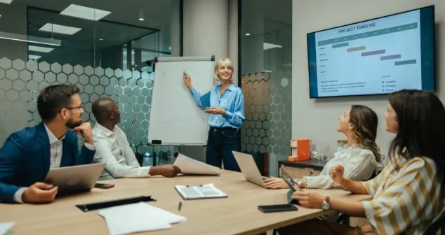 Project estimation pitfalls discussed as a team reviews a project timeline on screen during a planning meeting
