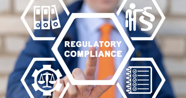 Common Mistakes for Medical Device Projects A businessman wearing a blue suit and an orange tie is pointing at a transparent virtual interface with hexagonal icons. The central hexagon displays the words "REGULATORY COMPLIANCE." Surrounding it are four smaller hexagons with white icons, including a scale inside a gear (symbolizing legal and ethical standards), a stack of binders (representing documentation), a checklist (indicating compliance requirements), and a person next to a legal symbol (denoting regulatory oversight). The background is blurred with a brick wall visible.