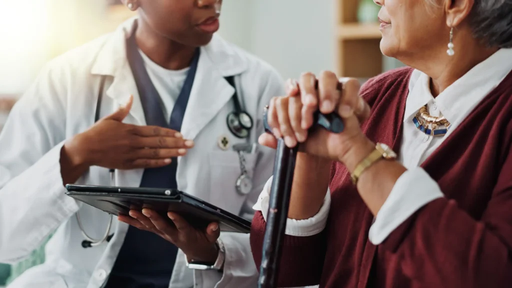 Care coordinator reviewing a connected therapy device alert with a patient before her next visit