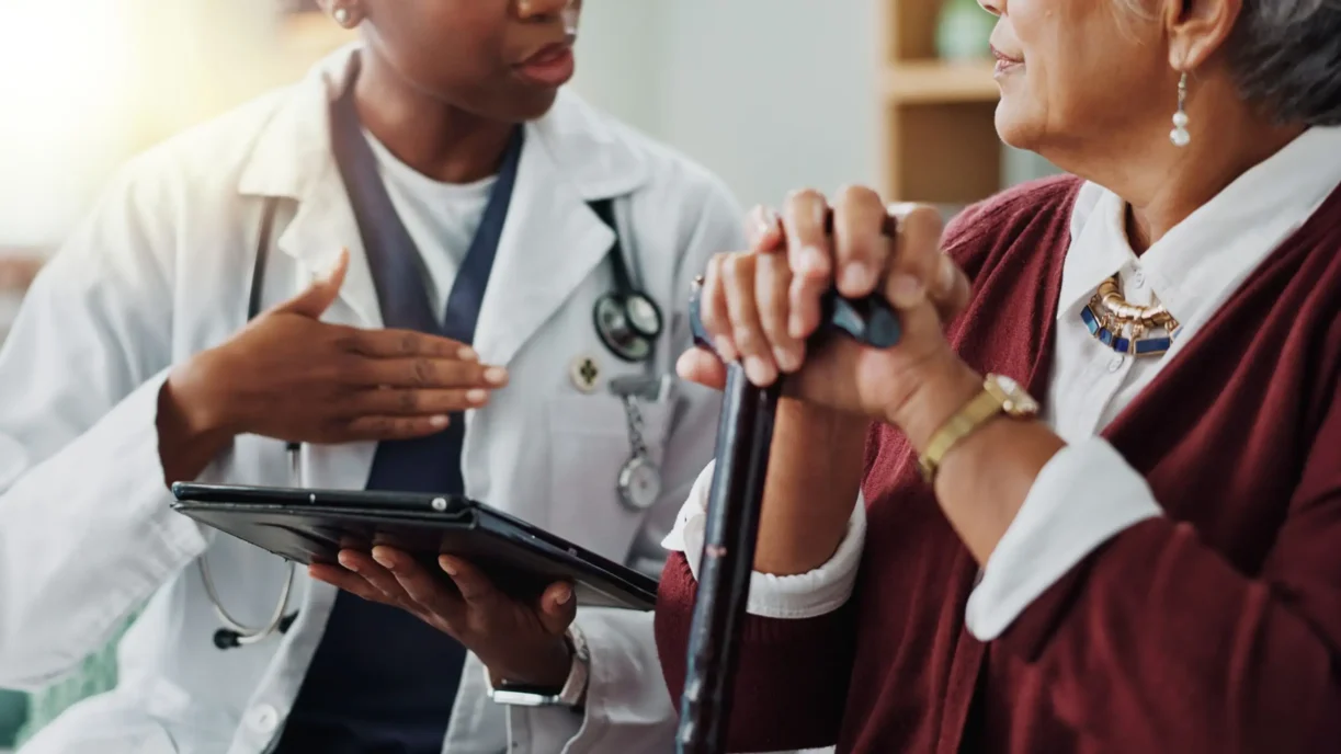Care coordinator reviewing a connected therapy device alert with a patient before her next visit