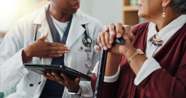 Care coordinator reviewing a connected therapy device alert with a patient before her next visit