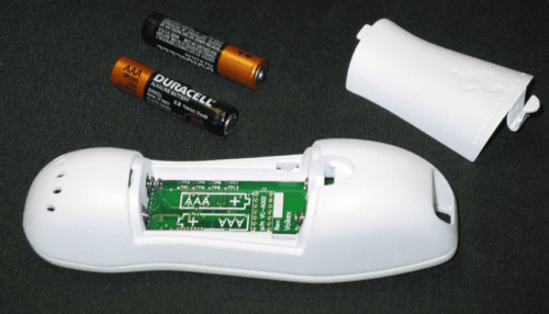 Baby Movement Tracker device opened to show internal compartment, electronics and AAA batteries placed beside the housing.