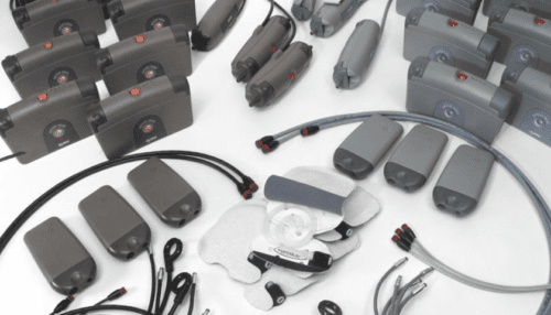 Overhead view of multiple LVAD system components including cables, handles and control modules arranged on a white background.