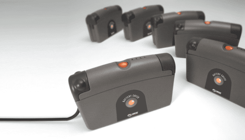 Multiple cardiac recovery system controller units arranged on a surface, showing the compact black housings with orange status indicators.