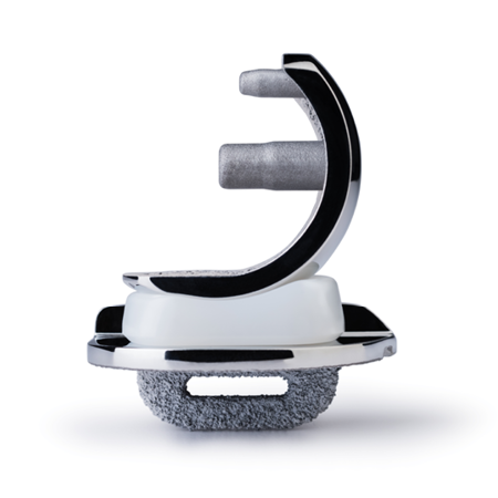 A close-up photo of a cervical disc replacement device. The implant features a metallic structure with an articulating white polymer insert and a textured lower surface for osseointegration. It is designed for spinal disc replacement surgeries to restore mobility and spacing between vertebrae.
