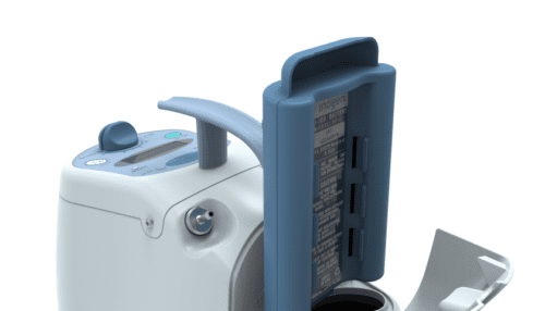 Inogen One Oxygen Concentrator displayed with removable battery and accessory components on a reflective surface.