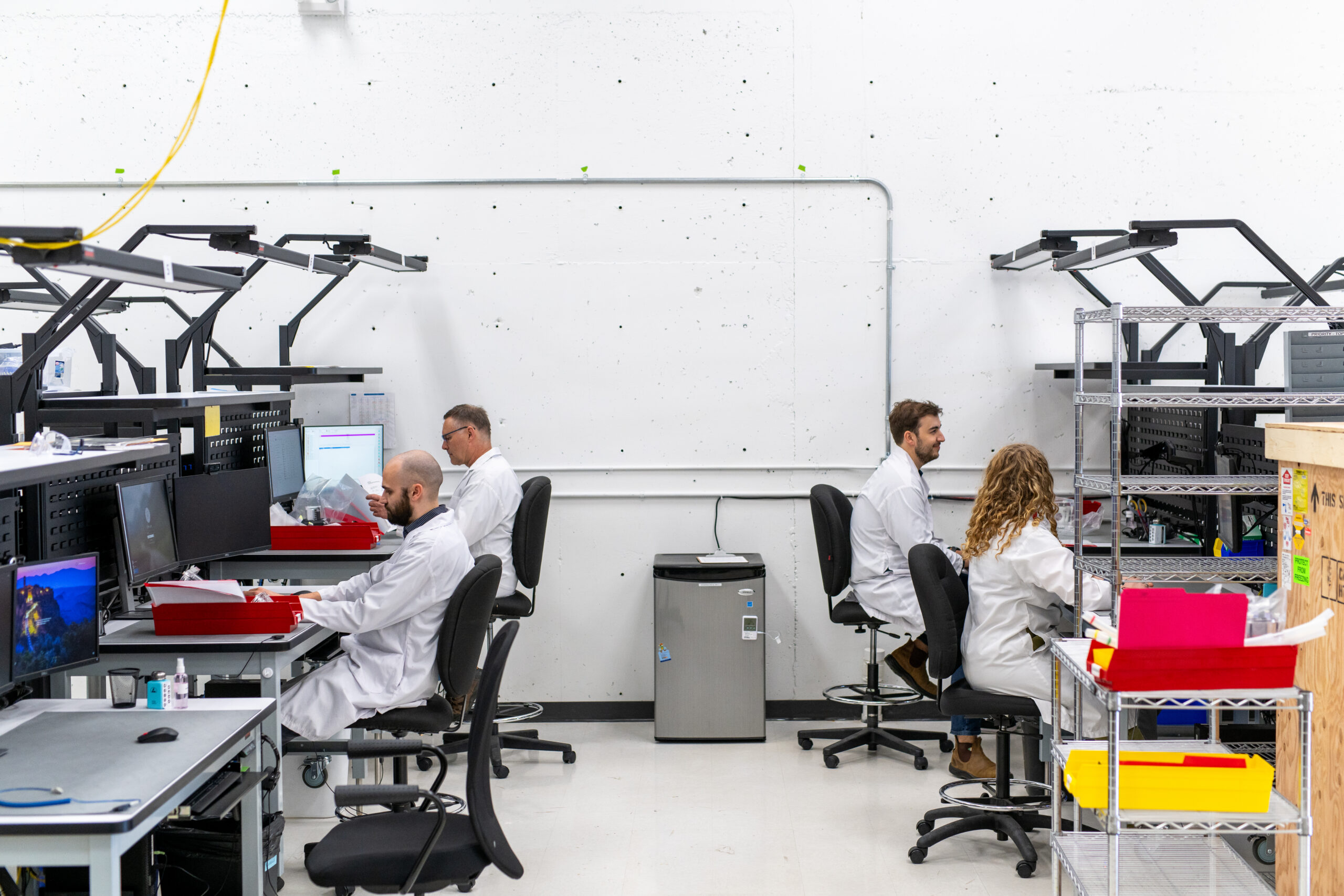 working with a contract manufacturer image of two rows of workers on assembly floor.