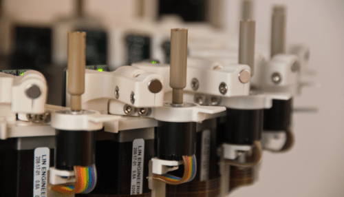 Close-up of the Plex ID pathogen detector fluidic module showing tubing, connectors and precision mechanical components.