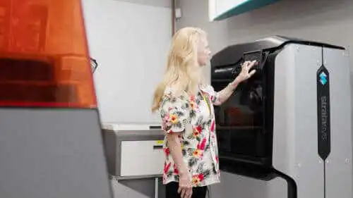 Engineer operating a 3D printer for medical device prototyping.