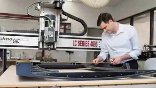 Engineer measuring prototype parts on a CNC machine in the Irvine facility.