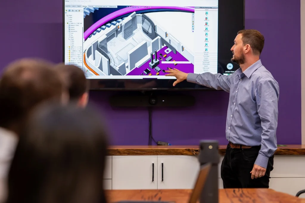 Engineer presenting a 3D CAD model during a design review meeting at StarFish Medical.