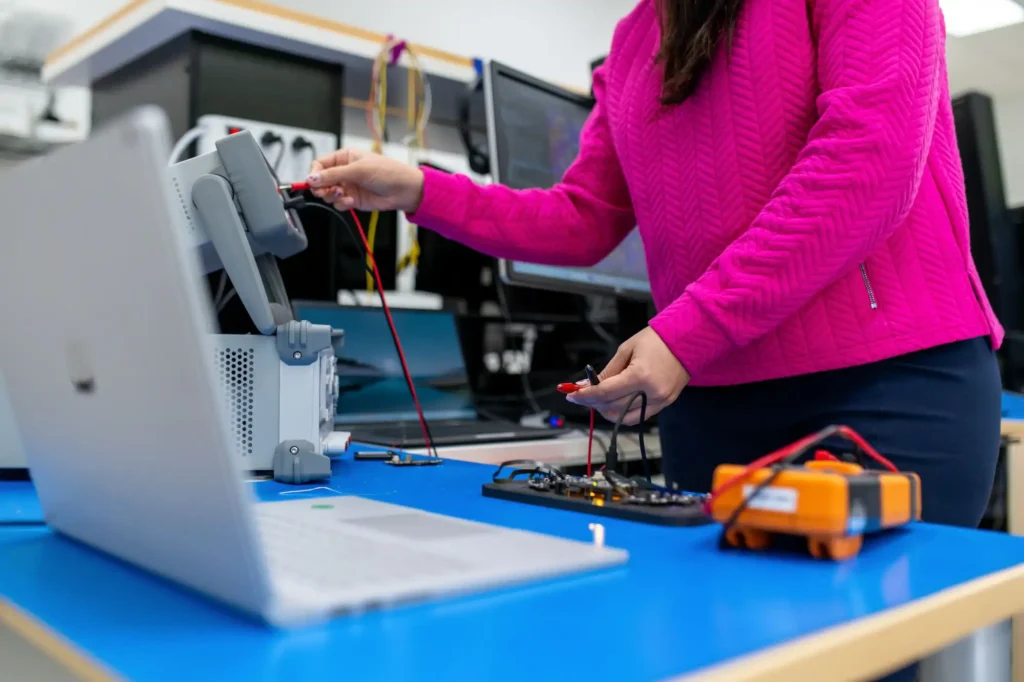 Engineer testing power stability and voltage regulation on medical device PCB using lab instruments and probes.