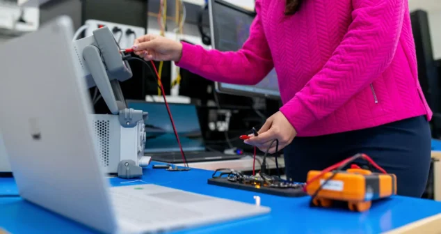 Engineer testing power stability and voltage regulation on medical device PCB using lab instruments and probes.