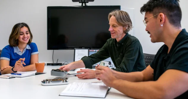 Team of engineers at StarFish Medical Toronto collaborating during a design review meeting with prototypes on the table.