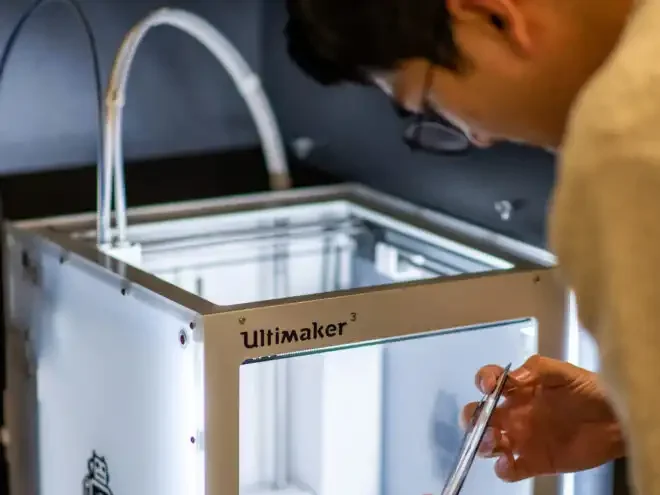 Medical Device Product Engineering Services Image of Engineer reaching into 3D printer