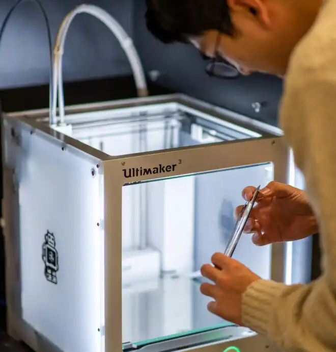 Medical Device Product Engineering Services Image of Engineer reaching into 3D printer