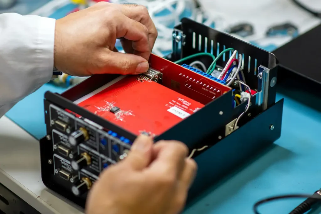 Engineer assembling electronic components during medical device design transfer process.