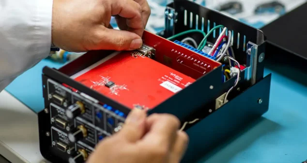 Engineer assembling electronic components during medical device design transfer process.
