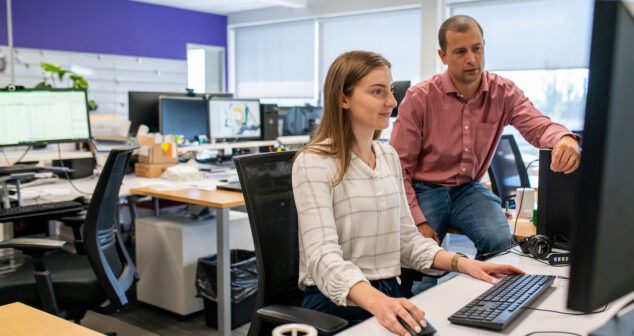 communication errors Accessibility description: Male and female discuss content on computer screen.