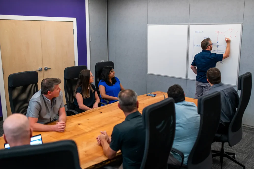 perfect. provide me with seo friendly alt text fort his image10:56 AMClaude responded: Technical team reviewing project estimation breakdown on whiteboard during engineering planning session (101 characters ✓)Technical team reviewing project estimation breakdown on whiteboard during engineering planning session