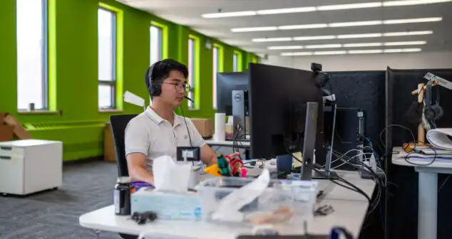 Engineer working on medical device design at computer workstation, demonstrating multidisciplinary expertise in MedTech innovation.