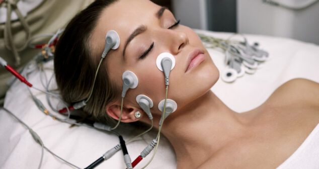 Wearable medical device Acessibility: Woman on hospital bed with various sensor attached to her head.