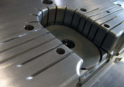 Detail of the core of a plastic injection mould made of aluminum presenting some deep channels (to obtain high ribs) and inserts.