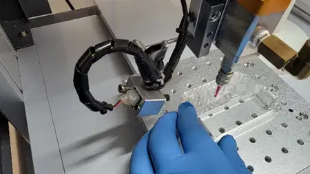 Automated adhesive dispenser applying fluid to a microfluidic device cartridge during manufacturing