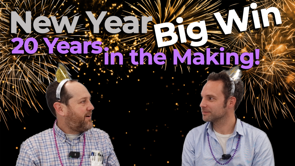 Two professionals wearing festive New Year’s accessories sit against a backdrop of fireworks. The text overlay reads "New Year Big Win: 20 Years in the Making!" emphasizing the celebration of a long-awaited achievement.