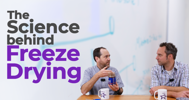 Two men sit at a table discussing the science behind freeze-drying. One of them holds a jar of freeze-dried coffee, illustrating the topic. The text overlay reads "The Science Behind Freeze Drying" in bold letters. A whiteboard with diagrams is visible in the background, reinforcing the technical discussion.