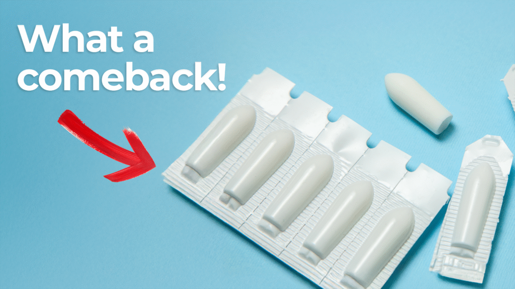 Illustration of suppository drug delivery method. Rectangular blister pack of suppositories, which are making a comeback in drug delivery, on a blue background with one suppository placed outside the packaging. Large bold text reads 'What a comeback!' with a red arrow pointing toward the suppositories, suggesting renewed interest or relevance.